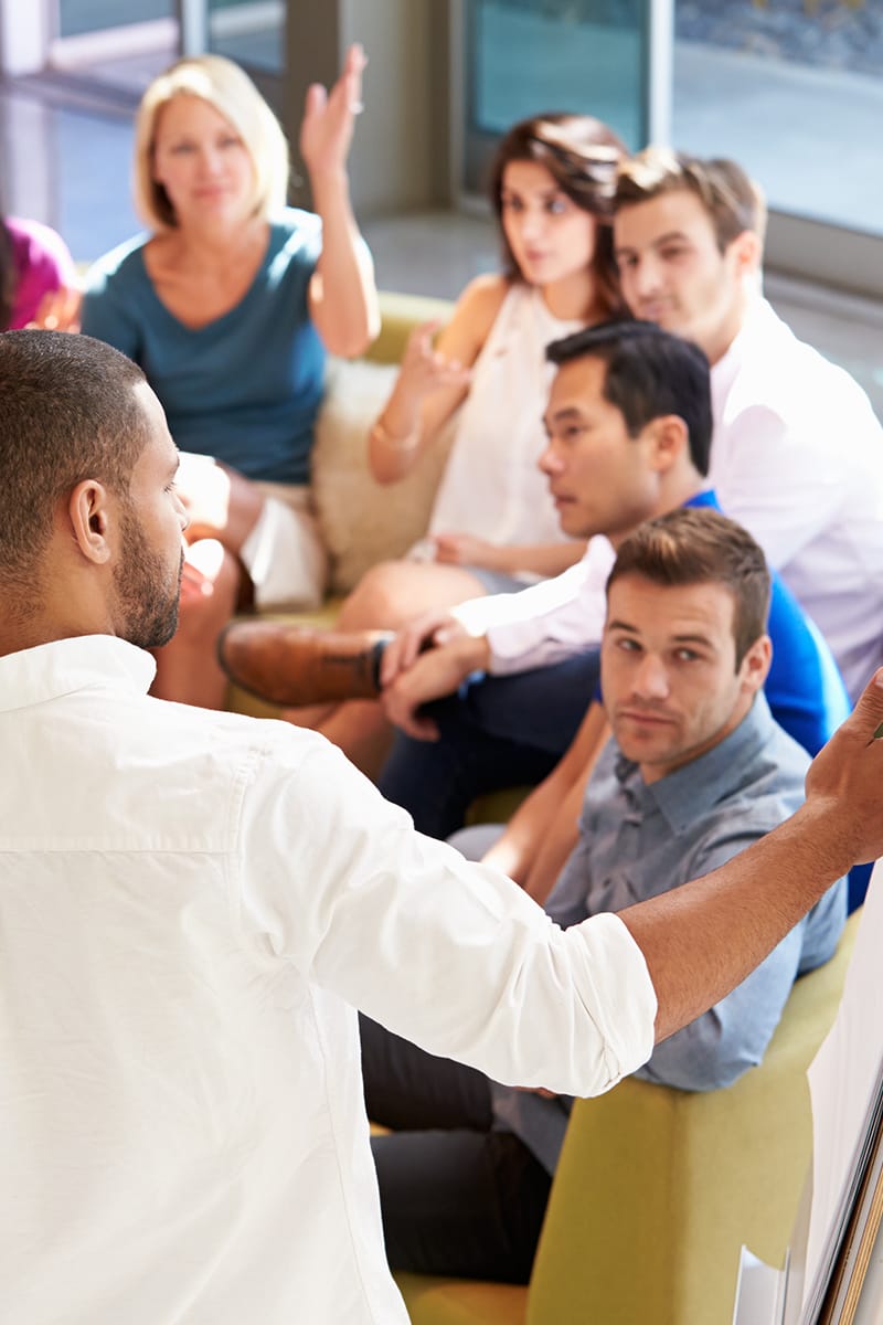 A man giving a presentation to his team members