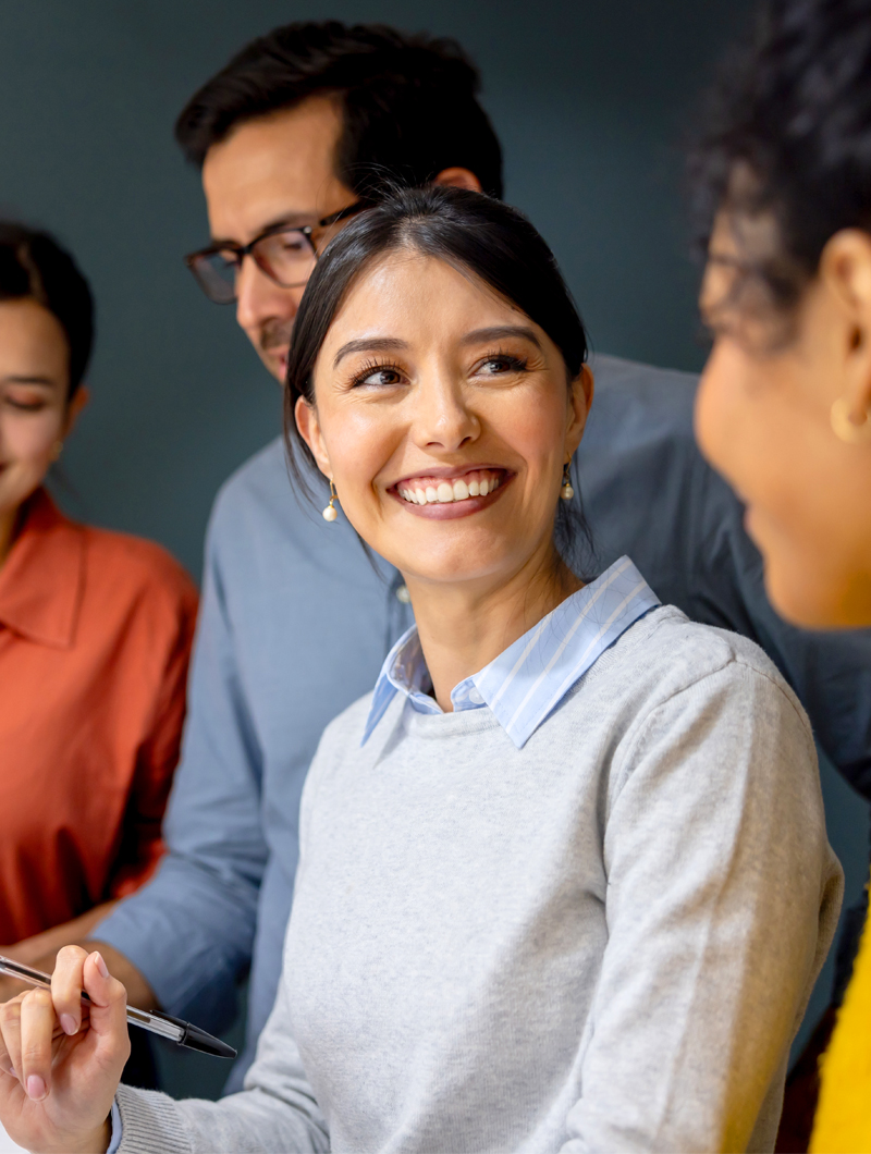 A woman experiencing work at its best, happy and standing out in her team, after her MCode Impact Session