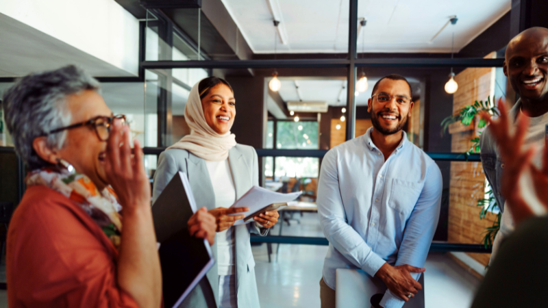 Group of coworkers chatting in a hallway.