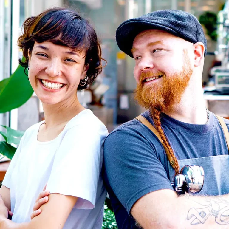 Two small business owners standing back to back