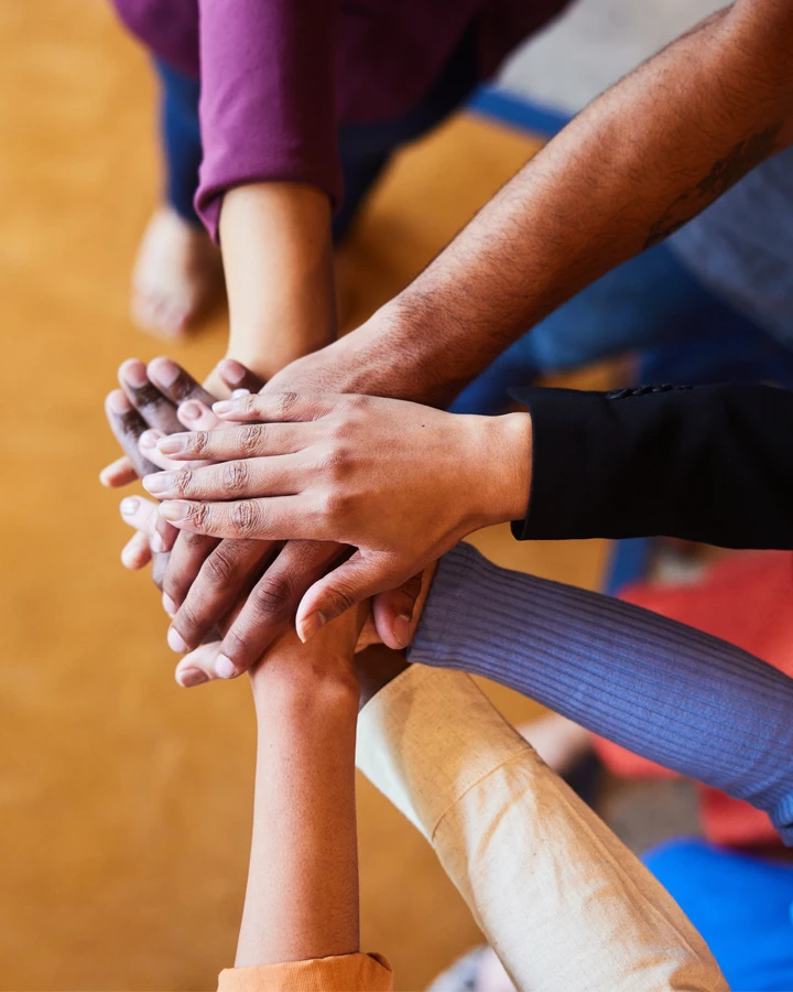 A group of Relators all putting their hands in together to celebrate a successful job done.
