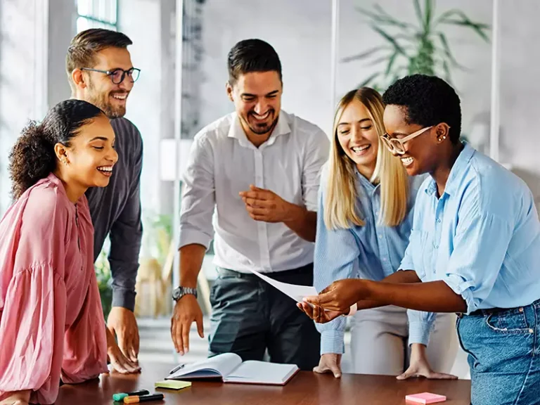 Team members laughing together while at work.