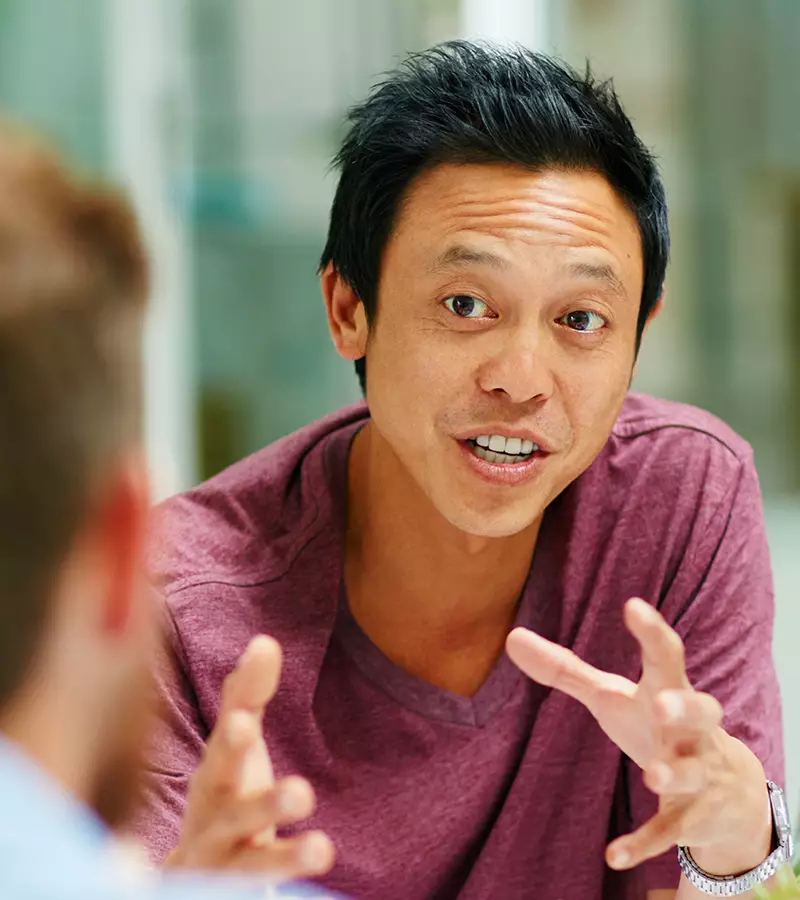 A high performer at work passionately talking with his hands.